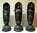 Kannon (de g. à dr.) aux onze têtes, aux six bras et aux mille bras. Dans ces deux dernières statues, la bodhisattva fait gasshō. (Musée Linden, Stuttgart)