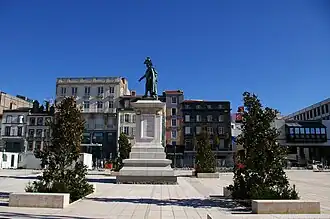 La statue du général Desaix (1848) encadrée de lauriers-tulipiers.