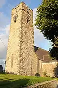 Photo d'une grande tour de pierre carrée baignée par les rayons du soleil