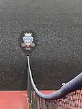 Logo de la Société Sportive du Jeu de Paume et de Racquets sur le court de jeu de paume.