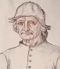 homme âgé très droit, en chapeau enveloppant la tête, habillé de gris clair.