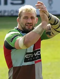un homme en maillot de sport applaudissant