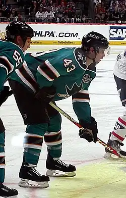 Photographie de John McCarthy avec le maillot turquoise des Sharks de San José.