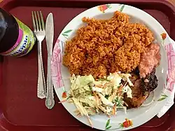 Riz wolof cuit à la ghanéenne accompagné de coleslaw et de poulet cuit au barbecue