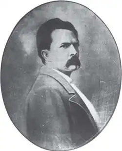 Photo ovale en noir et blanc montrant le portrait d'un homme moustachu