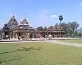 Vue d'angle : l'entrée, le petit temple dans la seconde entrée construit par Mahendravarman II, fils de Narhasimhavarman II qui a régné avec son père. Au fond le vimana du temple principal