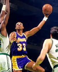 Abdul-Jabbar tentant un bras roulé par-dessus un adversaire, les bras en l'air.
