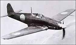 Photo noir et blanc d’un avion monomoteur à hélice et à aile basse en vol.