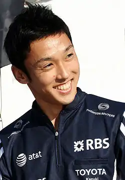 Photo d'un homme souriant, portant une veste de survêtement bleue