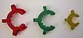 Clips de Keck. Trois tailles sont représentées : rodages 29/32 (rouge), 24/29 (vert) et 14/23 (jaune).