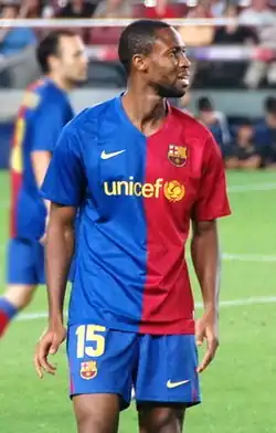 Photographie d'un joueur avec le maillot bleu et rouge de Barcelone, en train de regarder une tribune