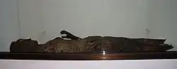 Vue générale d'une statue de bois de femme derrière une vitrine