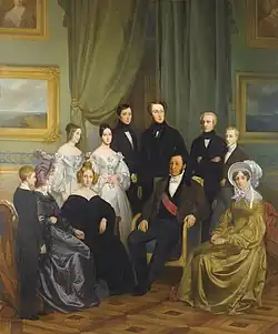 Huile sur toile représentant le roi Louis-Philippe, la reine Marie-Amélie, leurs huit enfants et Adélaïde, sœur du roi. Les hommes sont en habit, les femmes portent des tenues variées, robe noire, robes de couleur perle et de couleur ocre et mauve.