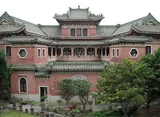 Cour intérieure du manoir, en direction du nord, montrant la véranda à trois côtés au premier étage et les toitures vertes plongeantes du bâtiment