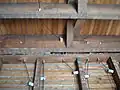 Isolateurs céramiques traversant en 1930 une charpente mur/plancher de maison bois aux États-Unis pour le passage de câbles.