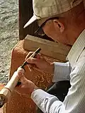 Artisan fabriquant une poupée kokeshi.