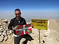 Alpiniste posant devant la plaque.