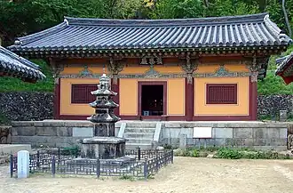 Photographie de la cour d'un temple. Un bâtiment d'un étage est visible dans le fond, ainsi qu'une statu dans la cour.