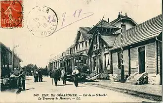 Le tramway de Munster à la Schlucht devant le poste frontière du col de la Schlucht dont l'ornementation du faîte en drakstil fait référence à la décoration de pignon nordique en vogue au XIXe&nbsp;siècle.
