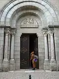 Le portail de l'église Saint-Étienne avec un pèlerin entrant.