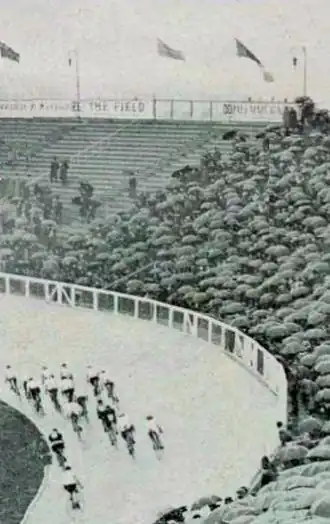 Photo d'un peloton de coureur cyclistes abordant le virage d'une courbe dans un vélodrome.
