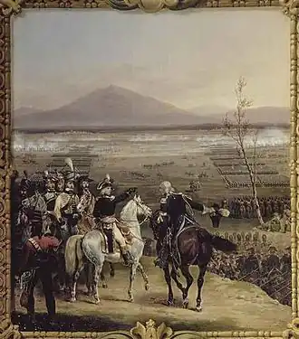 Scène montrant au premier plan un général à cheval accompagné de son état-major donnant un ordre à un de ses officiers en lui désignant une position au loin. En arrière-plan, de larges colonnes de soldats se dirigent sur le lieu des combats, perceptibles par de la fumée. Tout au fond, une montagne.