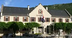 Bâtiment sur lequel est inscrit « Mairie » qui porte les drapeaux français et européen.