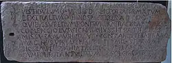 Photographie d'une pierre sur laquelle est gravée une inscription latine