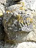Tête d'homme sculptée au portail de l'église.