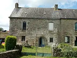 Maison du bourg avec linteau de porte mouluré.