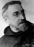 Photographie en noir et blanc d'un prêtre en robe de bure