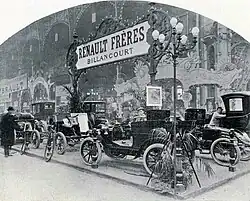 Photographie en noir et blanc d'une exposition de modèles de voiture.