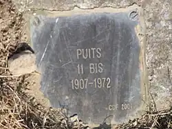 La plaque apposée sur la tête de puits matérialisée.