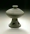 Coupe sur piédestal et couvercle. Grès incisé, glaçure naturelle, H. 12,7&nbsp;cm. Ve – VIIe&nbsp;siècle. Ancien Silla. LACMA