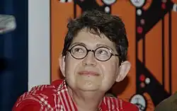 Femme avec des cheveux courts et des lunettes rondes regardant en l'air