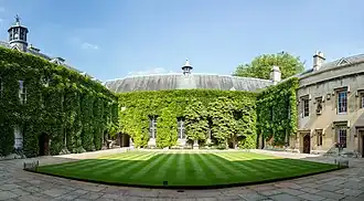 Extérieur d'un grand bâtiment ancien, en grande partie couvert de lierre.