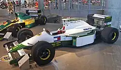 Photo de profil gauche de la Lotus 102, à la livrée blanche et verte