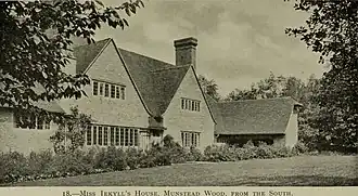 Photo en noir et blanc d'une grande maison entourée d'un jardin