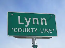 Panneau de signalisation vert sur fond blanc avec inscription Lee County Line