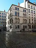Vue de l'extrémité sud de la rue (sur la gauche), vers le sud-ouest. L'espace dallé au premier plan est le parvis de la basilique et la place de l'Abbaye-d'Ainay.