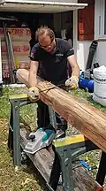 Travail à la plane pour retirer l'aubier tout en suivant le fil du bois et donner à la poutre une esthétique irrégulière.