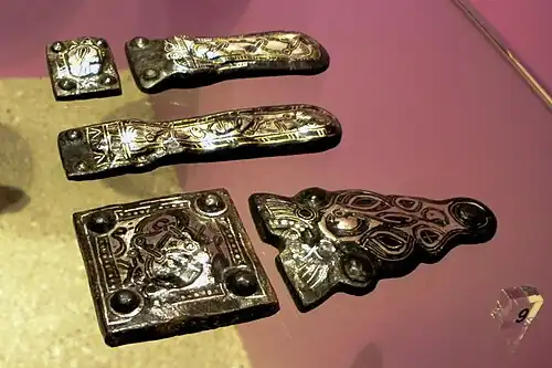 Damasquinage ordinaire mérovingien, d'or et d'argent sur plaques de ceinture en fer, VIIe&nbsp;siècle. Archeologisch museum de Maaseik, Belgique.