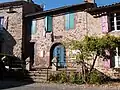 photo couleur de maisons à encadrement des ouvertures en pierre de taille rose-violacé.