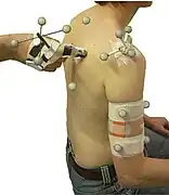 La palpation vraie (manuelle) peut être combinée à une palpation virtuelle (modèle 3D informatique, ici d'un genou, avec "points clés" anatomiques).