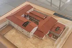 Photographie en plongée de la maquette d'une maison romaine : quatre ailes de bâtiments délimitent une cour centrale.