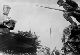 Philippe Pétain lisant son discours face au monument L'Assaut en 1927.