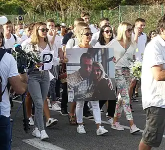 Marie, Véronique et Manon Monguillot (de gauche à droite), le 8 juillet 2020, lors de la marche blanche organisée en hommage à Philippe Monguillot (portrait).