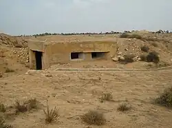 photo en couleurs d'un petit bunker émergeant des sables