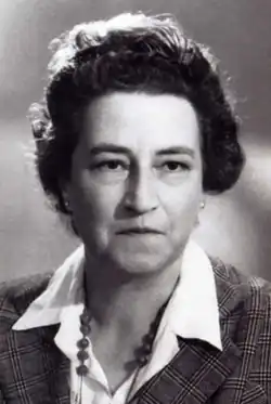 photo noir et blanc d'un visage de femme d'environ 45 ans, l'air décidé, cheveux bruns abondants coiffés un peu en hauteur et en arrière