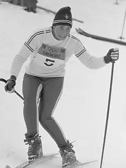 Photographie en noir et blanc d'une skieuse en course portant le dossard no&nbsp;5